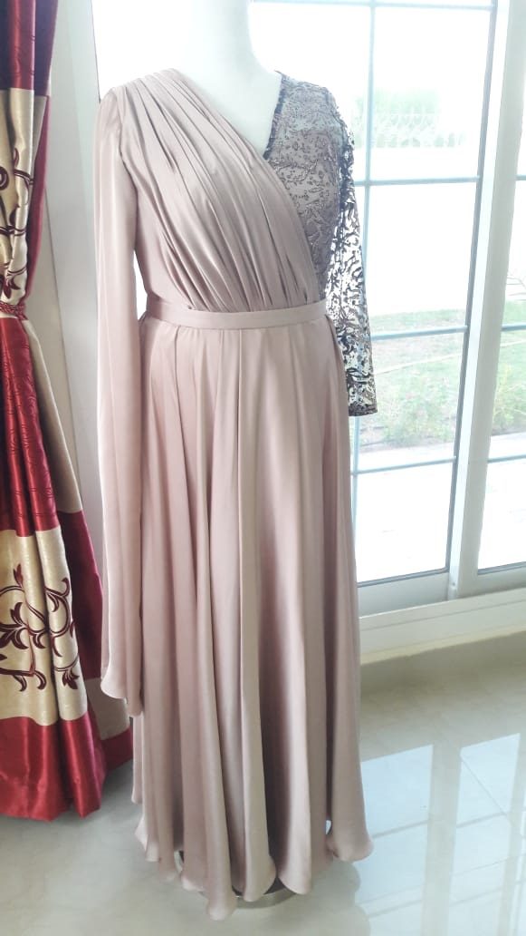 A blush pink gown with a draped bodice on a mannequin at Kyrah Fashions